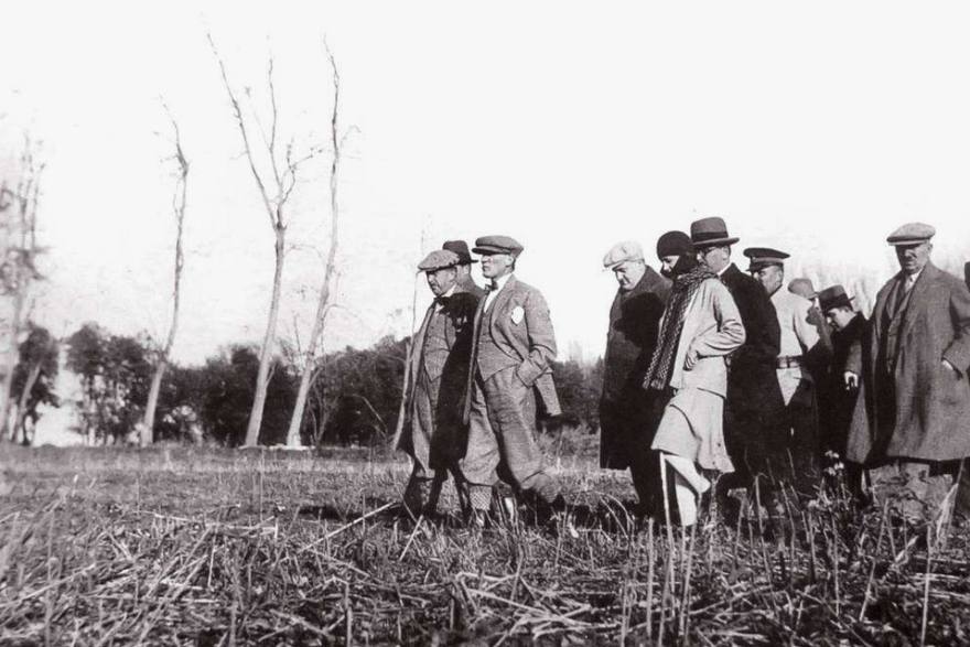 Inspecting a piece of farm machinery in the field.