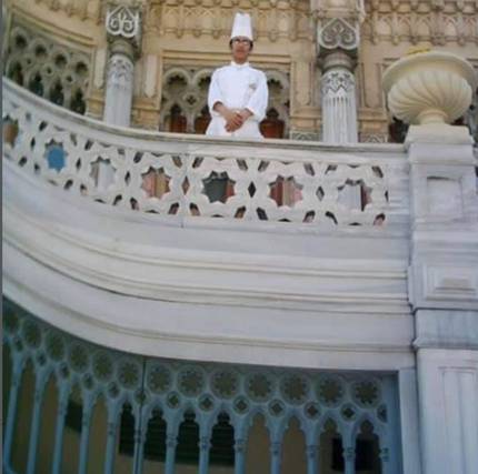 A young chef on the marble balcony of a historic building