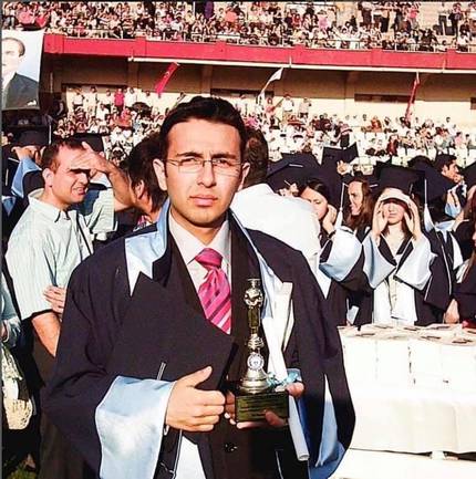 In graduation gown, holding the first-place trophy